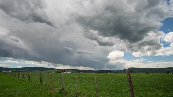 Storm clouds moving over green grassy valley in Wyoming