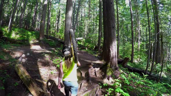 Woman carrying unicycle and passing through the forest 4k