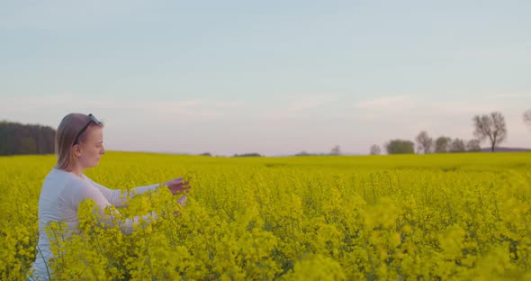 Female Farmer Examining Oilseed Rape Field