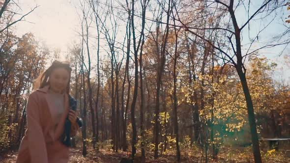 Happy Young Woman Is Running in Fall Day in Woodland, Frontal View