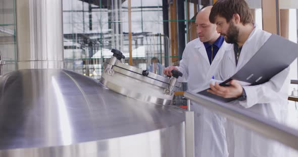 Two Caucasian Mans Working at a Brewery Factory