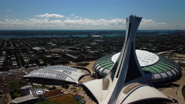 A close drone shot of Olympic Stadium and Biodome in Montreal with St-Lawrence river, during summer