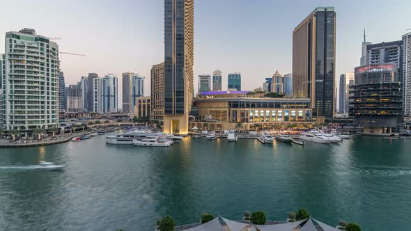 Aerial Vew of Dubai Marina with Shoping Mall Restaurants Towers and Yachts Day to Night Timelapse