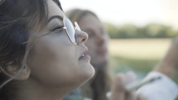 Closeup Side View Young Caucasian Woman Sunglasses Smoking Joint Blurred Man Background