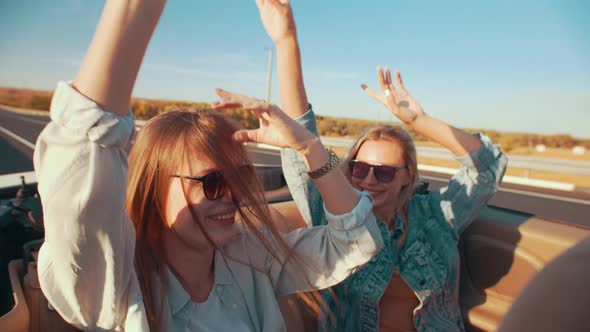 Two Beautiful Young Women Ride in a Cabiolet . On a Beautiful Summer Day, Two Friends Go on a Trip