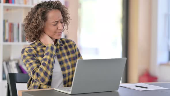 Young Mixed Race Woman with Neck Pain Using Laptop at Work 