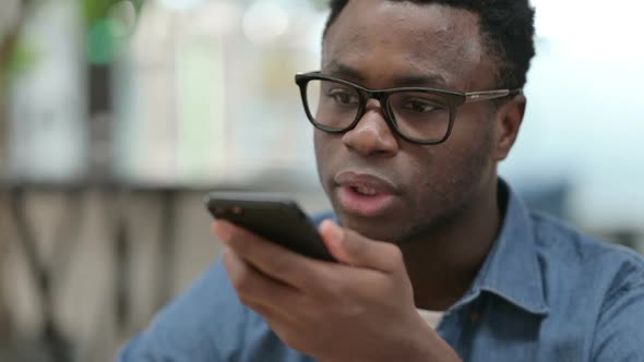 Close Up of African Man Talking on Smartphone Speaker