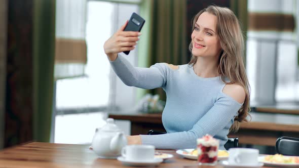 Smiling Beautiful Young Woman Taking Selfie Using Smartphone Posing at Cafe