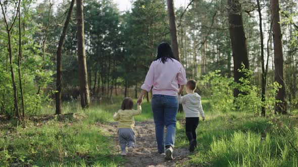Mom with Children Walks in the Woods the Family is Happy Together