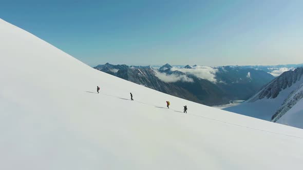 Group of Alpinists Is Advancing As Roped Team in Snowy Mountains. Aerial View