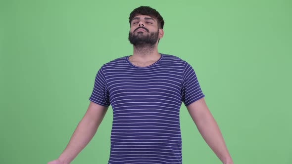 Happy Young Overweight Bearded Indian Man Relaxing with Eyes Closed