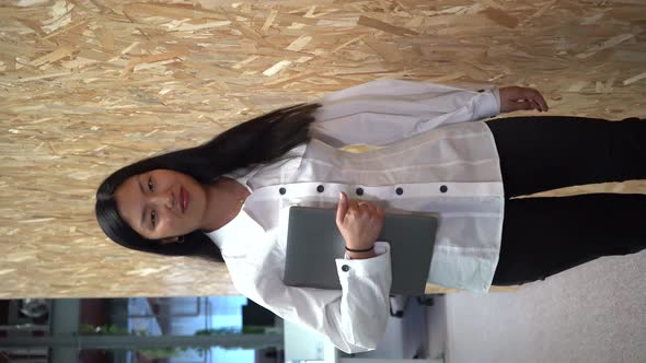 Asian businesswoman with laptop in modern workplace