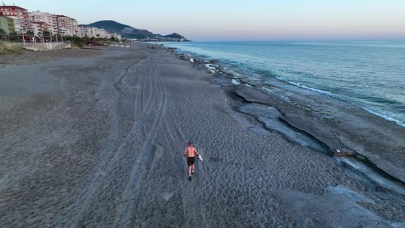 A man runs on the beach aerial view 4 K Turkey Alanya