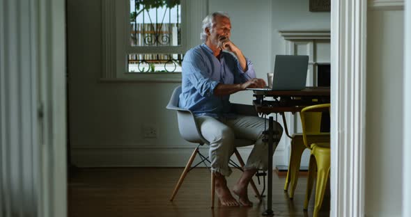 Senior man using laptop at home 