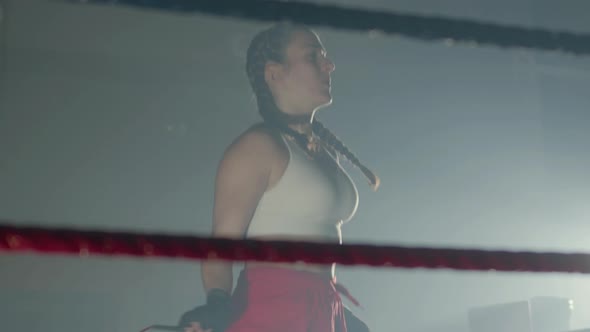 Young Caucasian Woman with Pigtails Jumping Rope in Boxing Ring