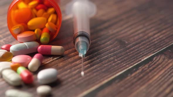 Syringe and Pills on Dark Background Close Up