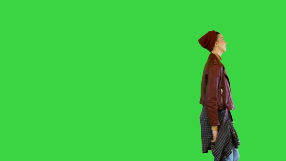 Young Girl in Stylish Urban Clothes Walks Dancing Slightly on a Green Screen Chroma Key