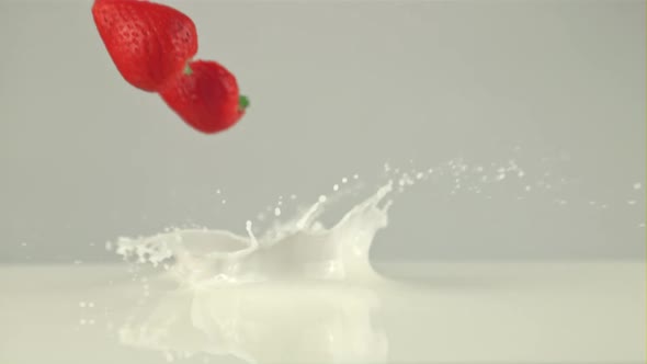 Super Slow Motion Sliced Strawberries Falls Into the Milk with Splashes