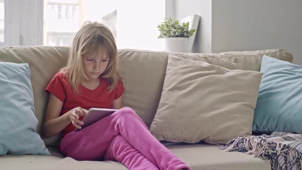 Little Girl Playing on Tablet alt