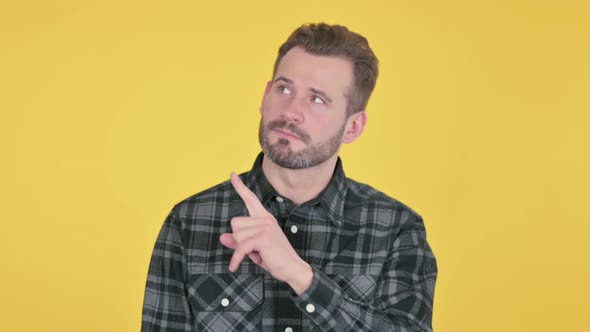 Portrait of Middle Aged Man Pointing Towards Product Display