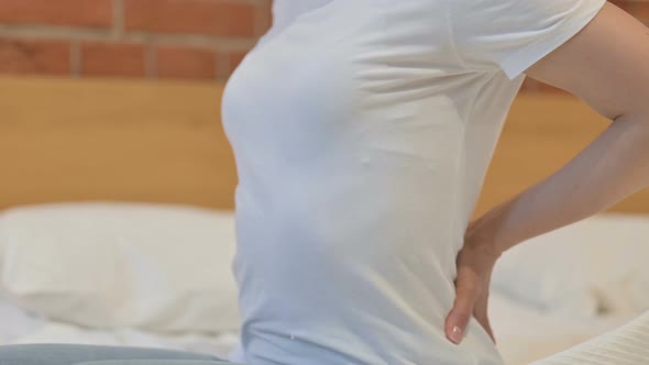 Close up of Young Indian Woman having Back Pain in Bed