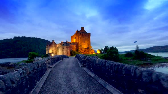 Footpath to the beautiful illuminated Eilean Donan Castle at sunset in Scotland