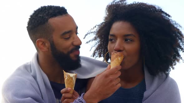 Couple eating ice cream cone at beach 4k