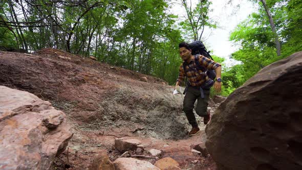 slow-motion of man traveler with backpack running in the natural forest