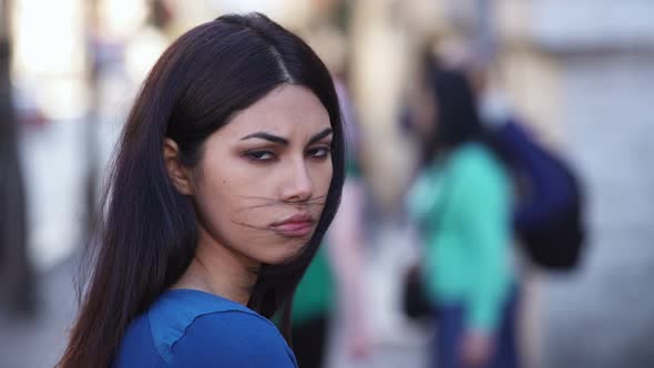 Sad and serious pretty oriental woman staring at camera- outdoor