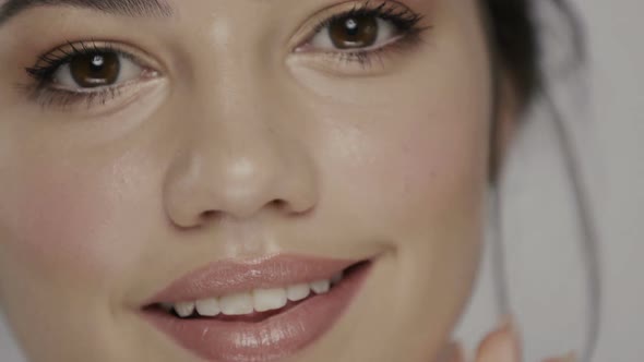 Close-up Portrait of Cute Girl Cleaning Face with Cotton Pad and Smiling