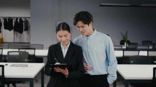 Japanese Male And Female Colleagues Talking Walking In Modern Office