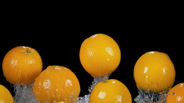 Delicious Oranges are Bouncing From Water with Splashes on the Black Background