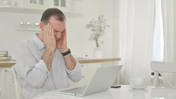 Stressed Middle Aged Man Having Headache at Home