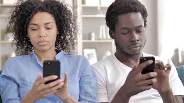 African Man and Woman Using Smartphone