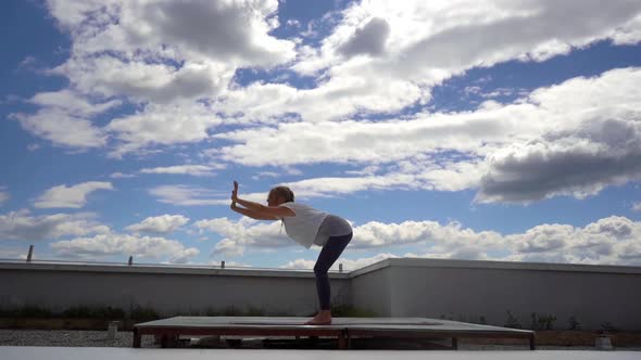 Young Attractive Woman Is Practicing Yoga, Standing Forward Bend Exercise