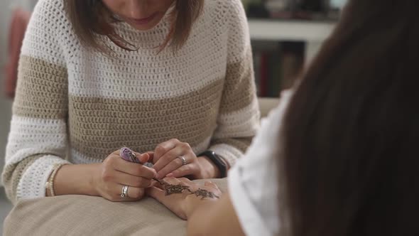 Master Mehendi Is Engaged in Drawing a Flower Amulet for a Visitor