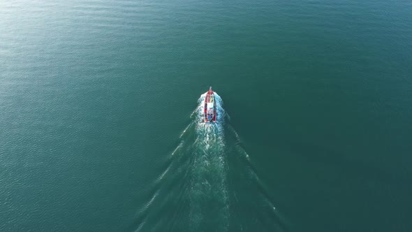An aerial view from a drone flying above a fishing boat