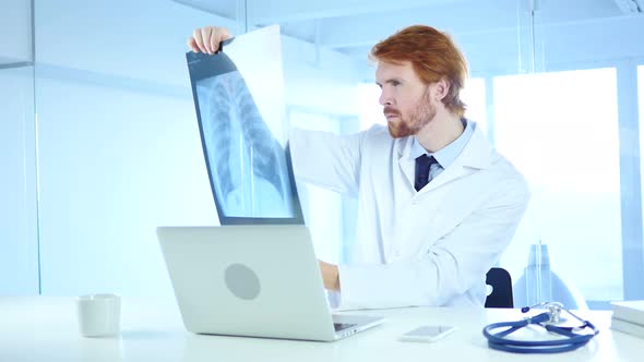 Serious Doctor Checking X-ray of Patient for Diagnosis