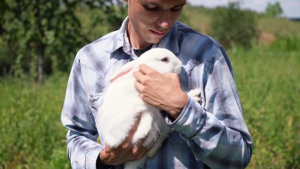 Young Boy of Caucasian Ethnicity Blue Checkered Shirt Holds a Cute Fluffy Domestic White Rabbit in