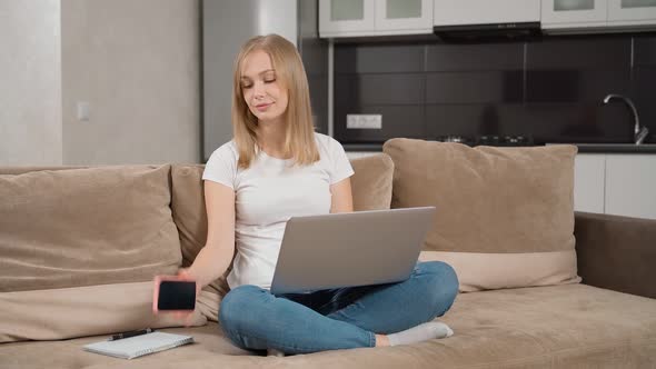 Oman Having Mobile Conversation While Working on Laptop