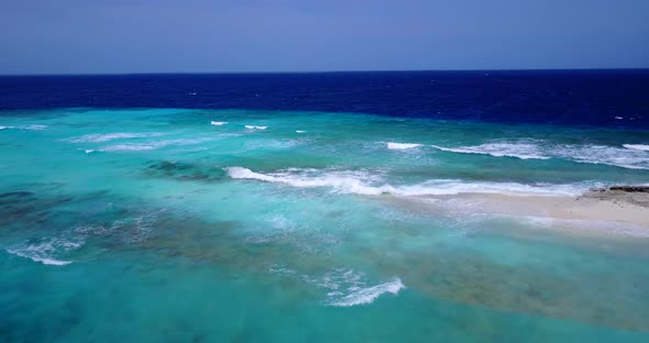 Beautiful overhead clean view of a paradise sunny white sand beach and blue ocean background in vibr