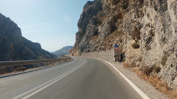 POV car riding through mountain national road in autumn. Auto driving at sunny countryside route