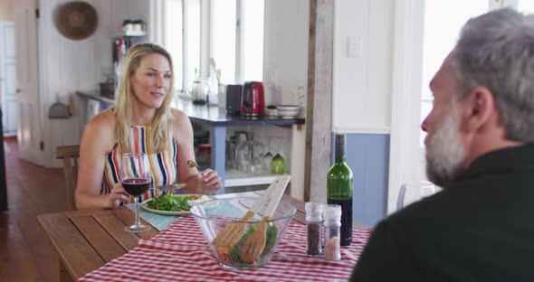 Happy caucasian mature couple smiling, talking and enjoying meal together