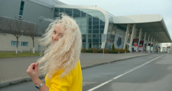 A Beautiful Girl in a Yellow Sweater Is Going To the Airport. Beautiful Smile. Sunny Day. 