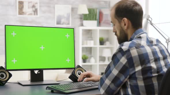 Man Looks at Green Screen PC Display in Well Lit Home