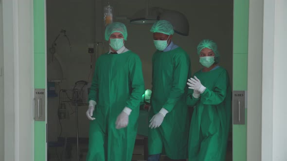 Team surgeon in uniform success surgery and walking go out from operating room at hospital.