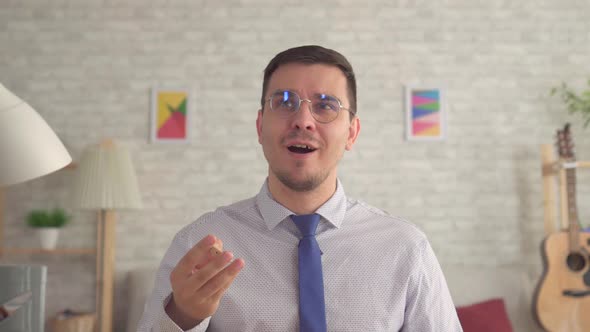 Man in the Living Room Removes the Hearing Aid From His Ear and Hears