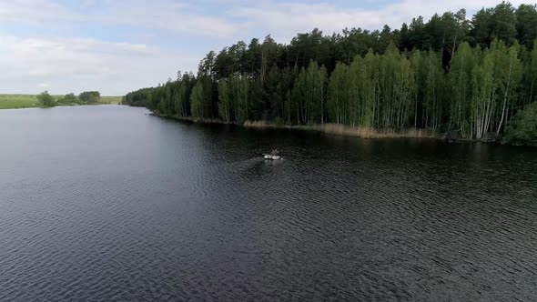 Aerial view of lake with equipped fishing piers and two fishermens in a boat fishing. 06