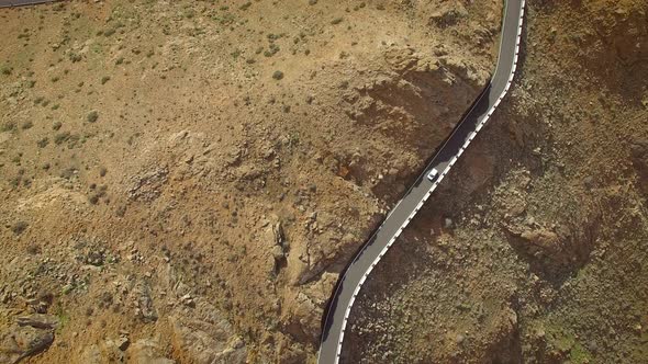 Aerial view of a car driving on a winding mountain road in Fuerteventura.