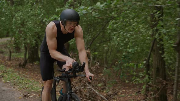 Triathlete Rides a Bike Pro Cyclist Rides on a Forest Road Preparation for Competitions and